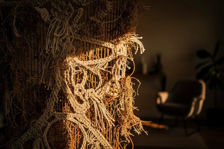 Illustration von einem umgedrehten Makramee-Wandbehang, dessen kunstvolle Knotenstruktur und organische Rückseite im Vordergrund stehen.